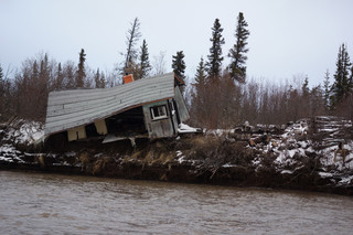 Collapsing cabin on an eroding river bank in the Mackenzie Delta. May 2018. Photograph by Franz Krause.